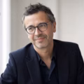 Portrait d'un homme à lunettes en veste bleu marine.